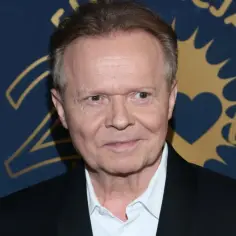Michał Bajor z partnerem na tle złoto-granatowej ścianki z napisem "25 lat".