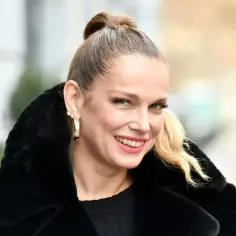 Uśmiechnięta Joanna Liszowska w czarnym płaszczu, marząca o swoich dzieciach.